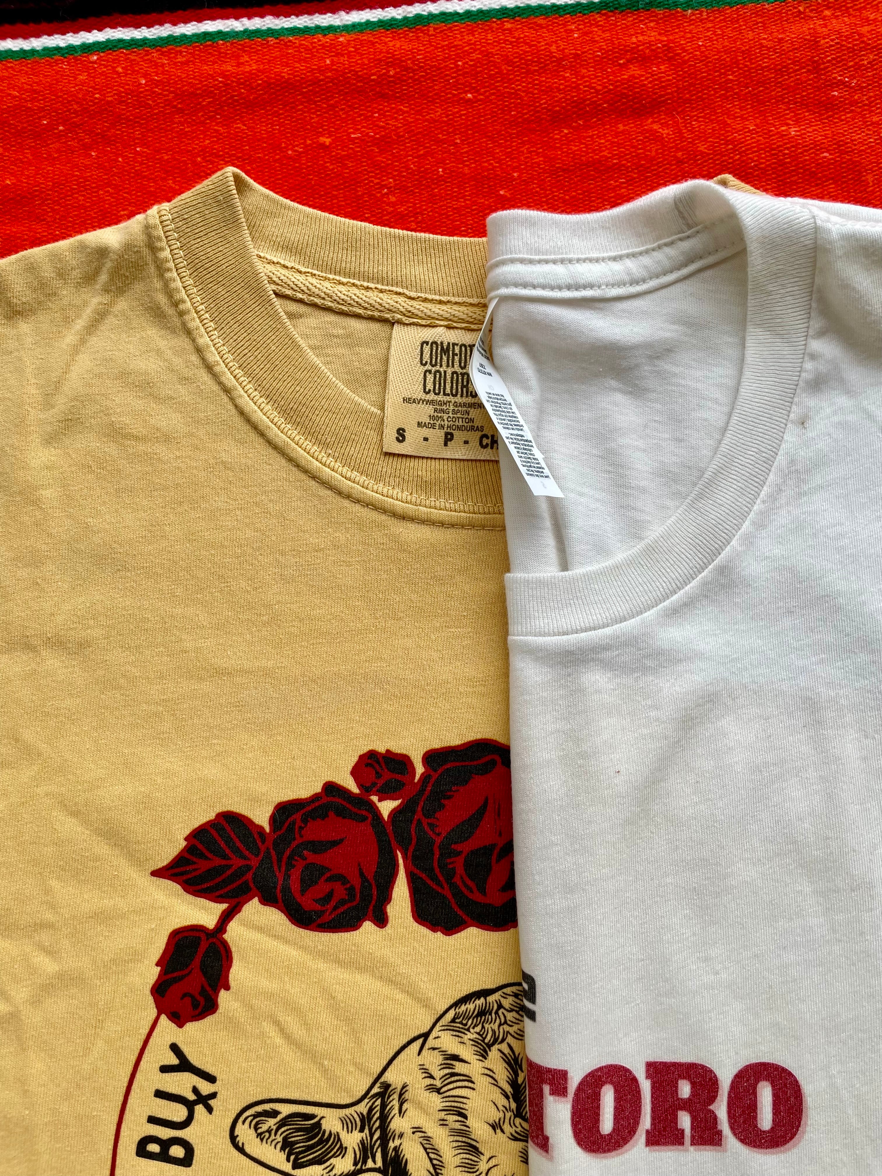 Mustard Yellow western graphic tee with cow head and red roses, bold slogan “Can Buy Myself Cattle” inspired by Miley Cyrus. Feminine cowgirl shirt with country sass and southern style. Rodeo-ready and perfect for bold fashion lovers.