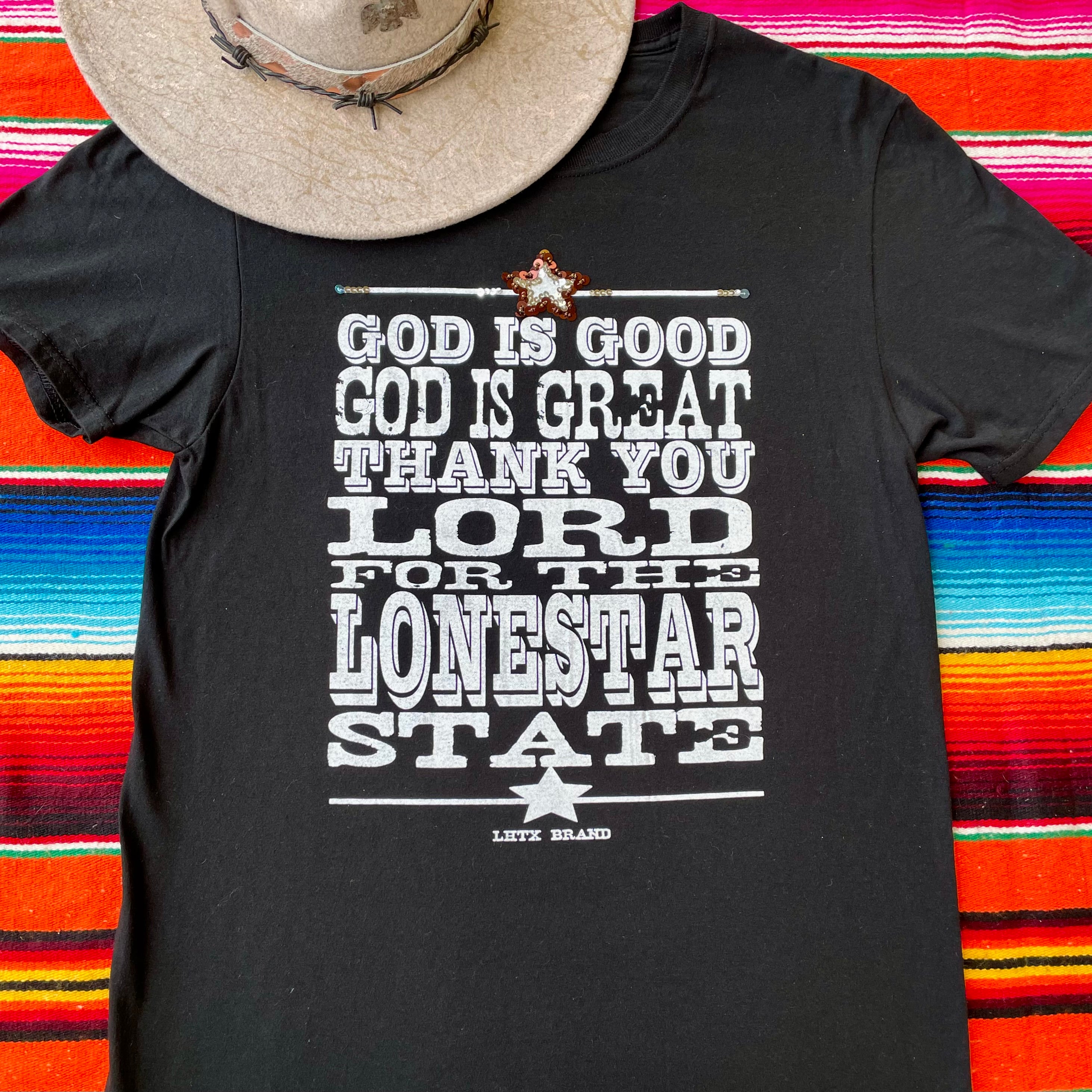 Black t-shirt with text design on a colorful striped background