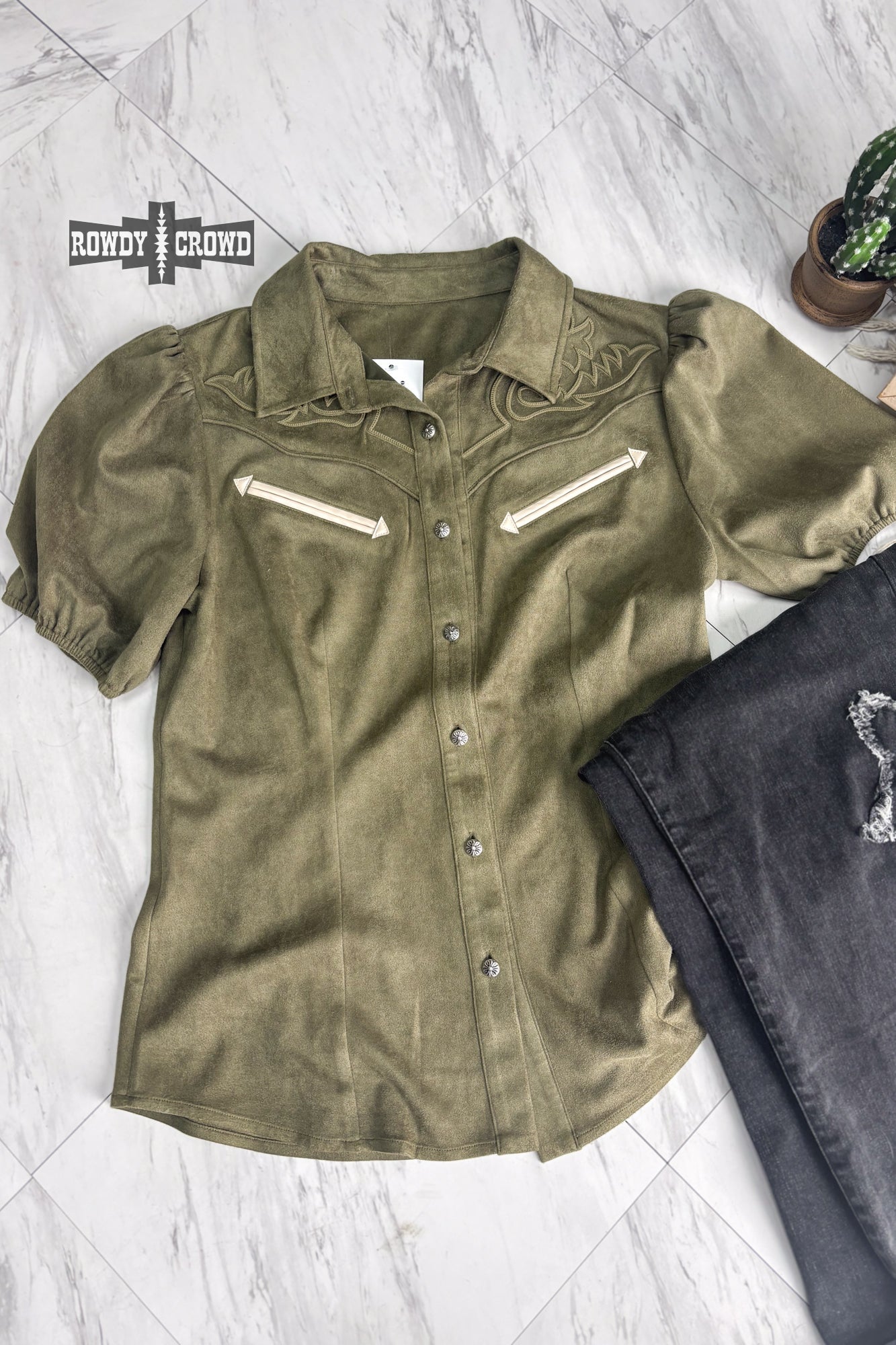Woman in a western style Rowdy Crowd button up green shirt and black pants