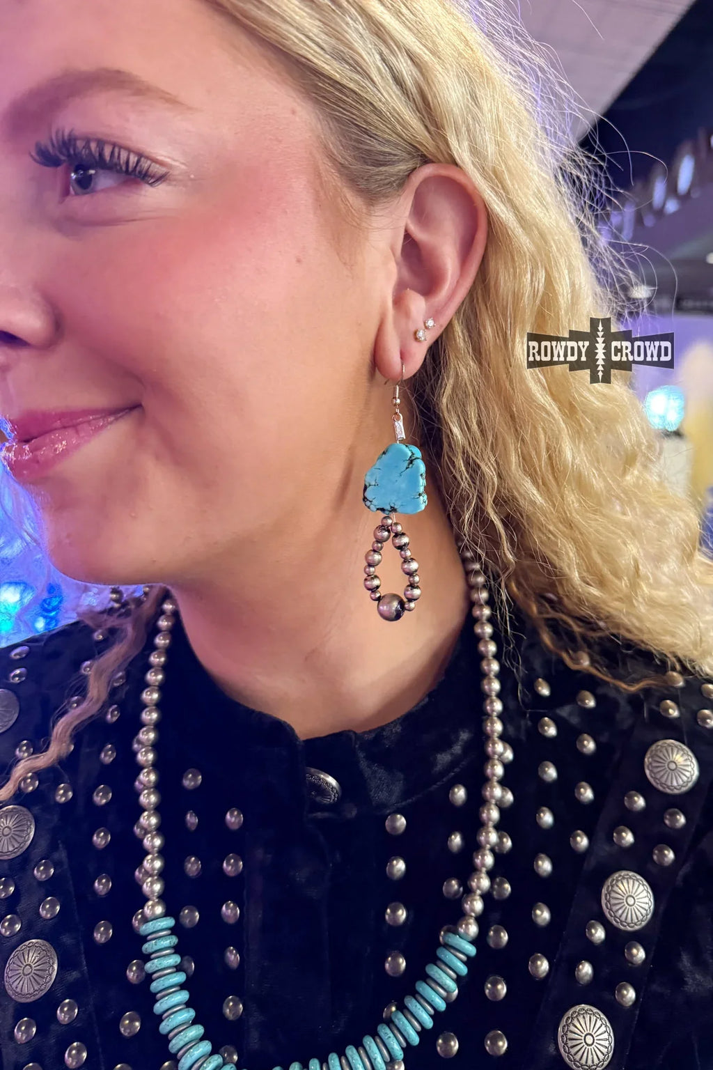 cowgirl wearing turquoise western earrings at rodeo