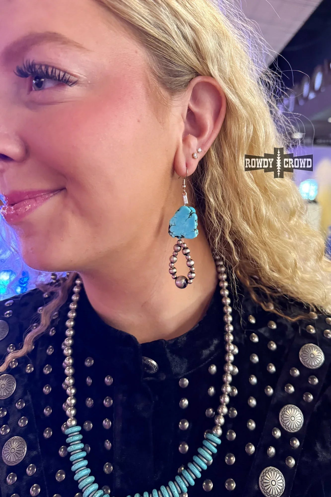cowgirl wearing turquoise western earrings at rodeo
