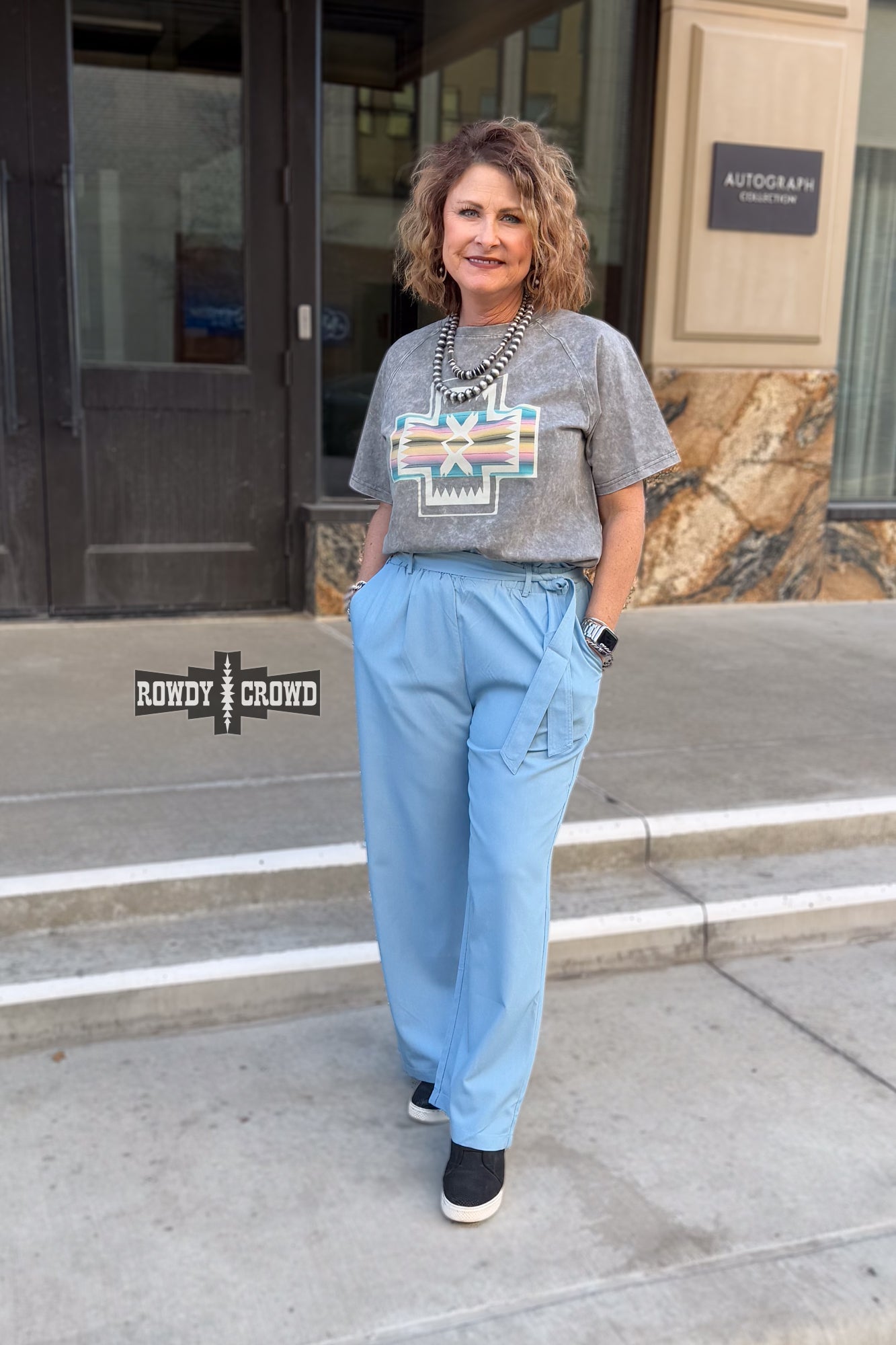 Woman standing in front of a building wearing Rowdy Crowd Ocean Breeze light blue Pants 