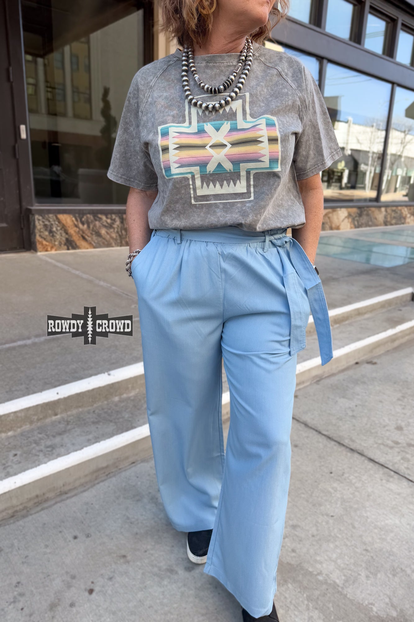 Woman standing in front of a building wearing Rowdy Crowd Ocean Breeze light blue Pants 