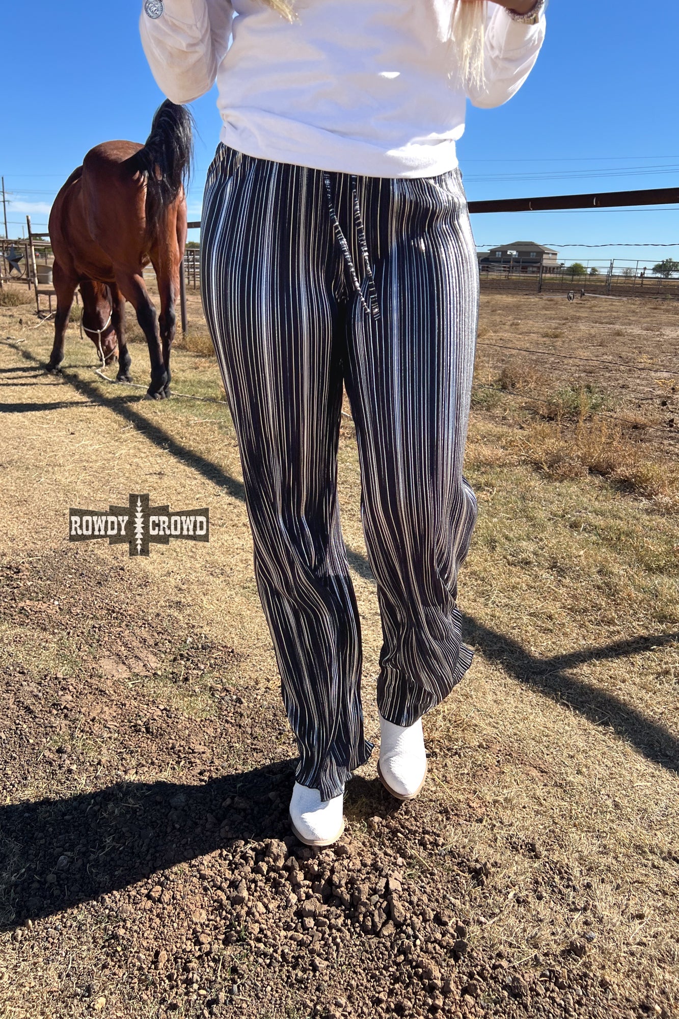 Person wearing a graphic t-shirt and Rowdy Crowd Ruffled Cup wide leg striped pants 