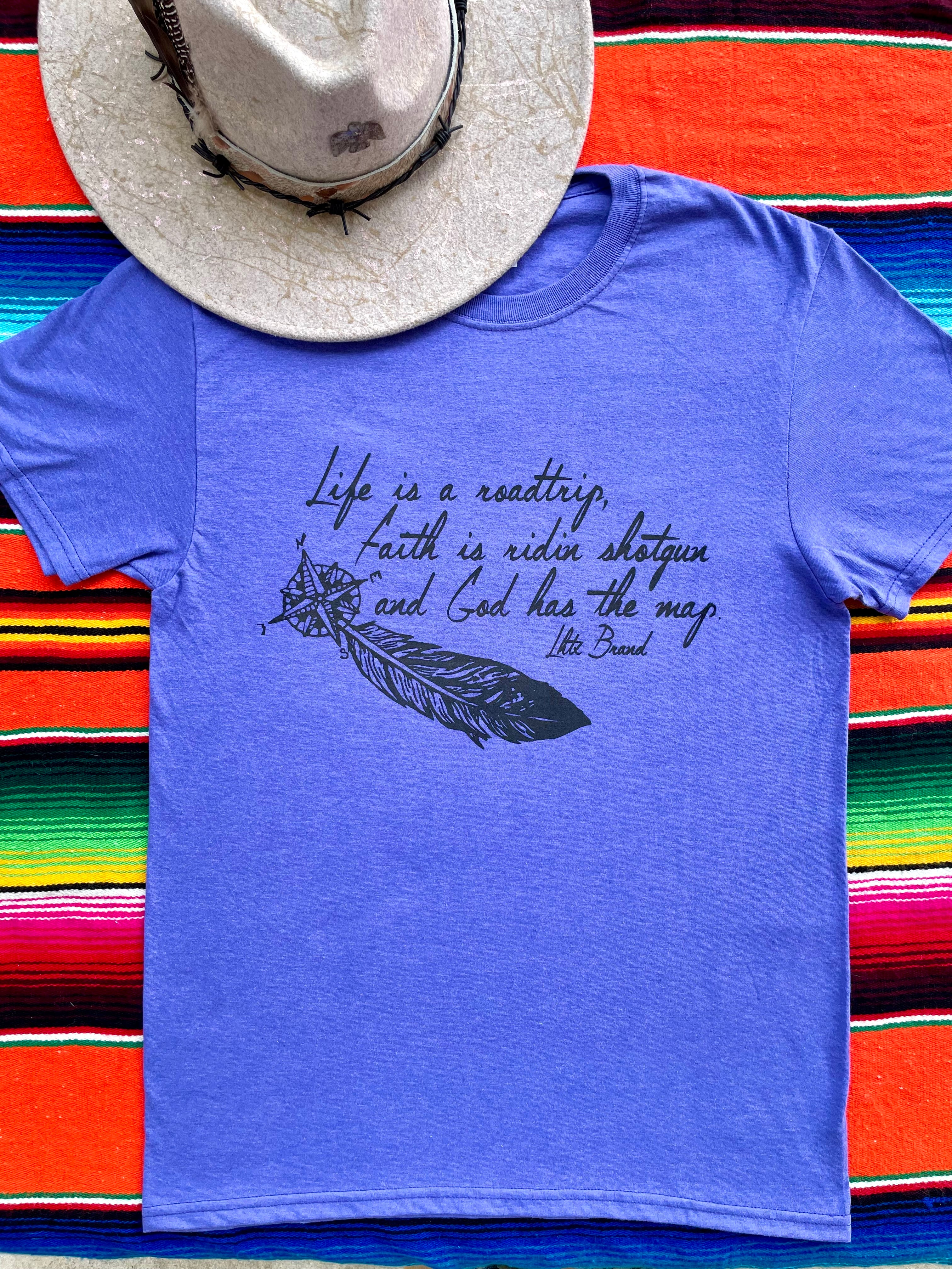 Blue t-shirt with text and feather graphic on a colorful striped background