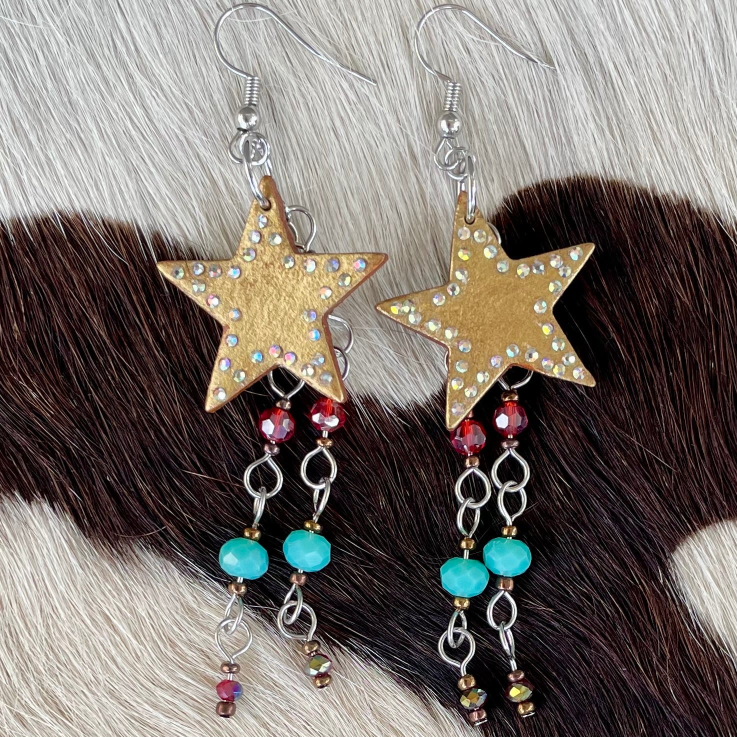 Handmade golden starburst earrings with leather accents and rhinestone sparkle 