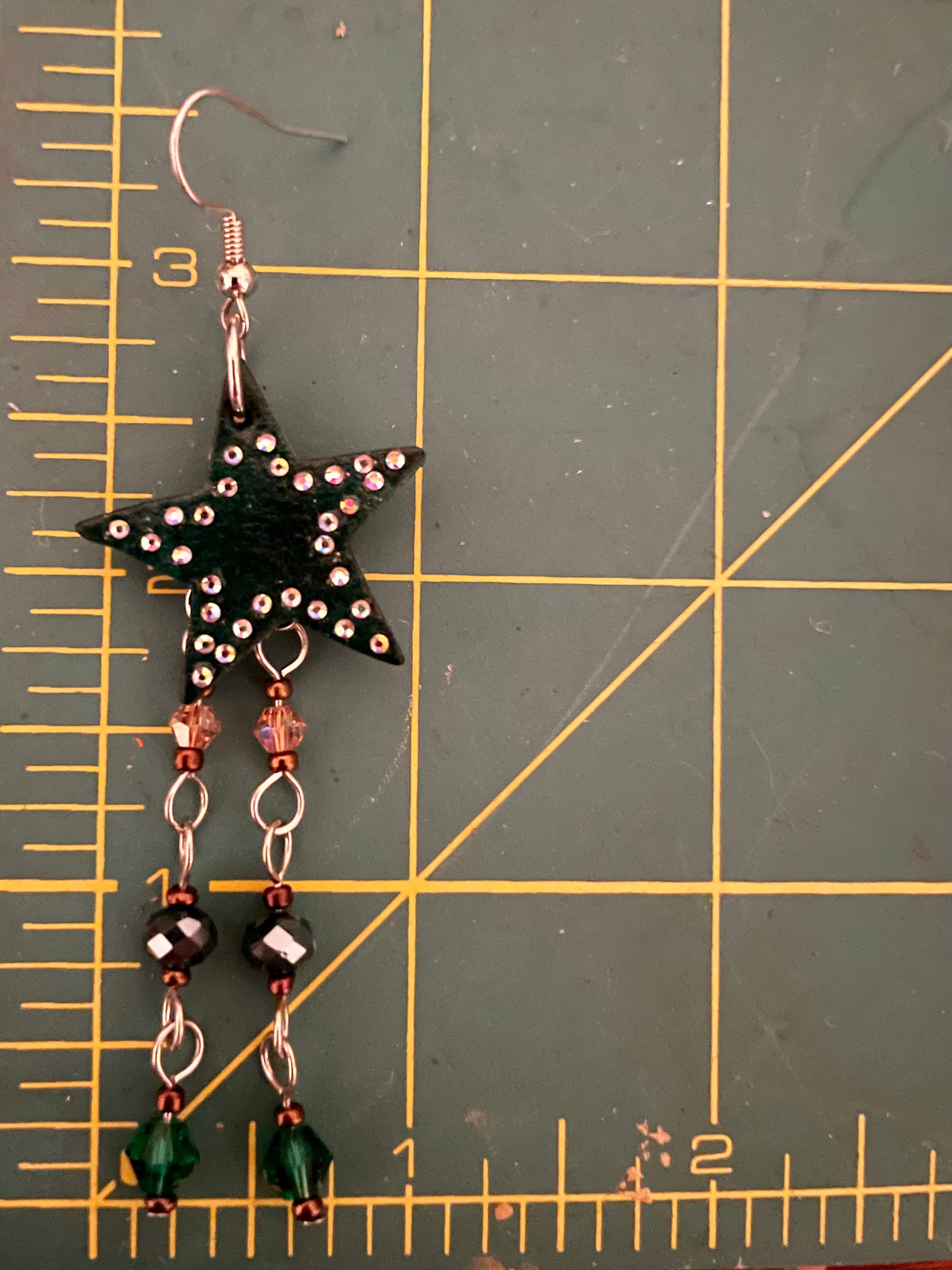 Hunter green leather star earrings with multicolored hanging beads and adorned with rhinestones, handmade western jewelry for cowgirls and nature-inspired fashion lovers.