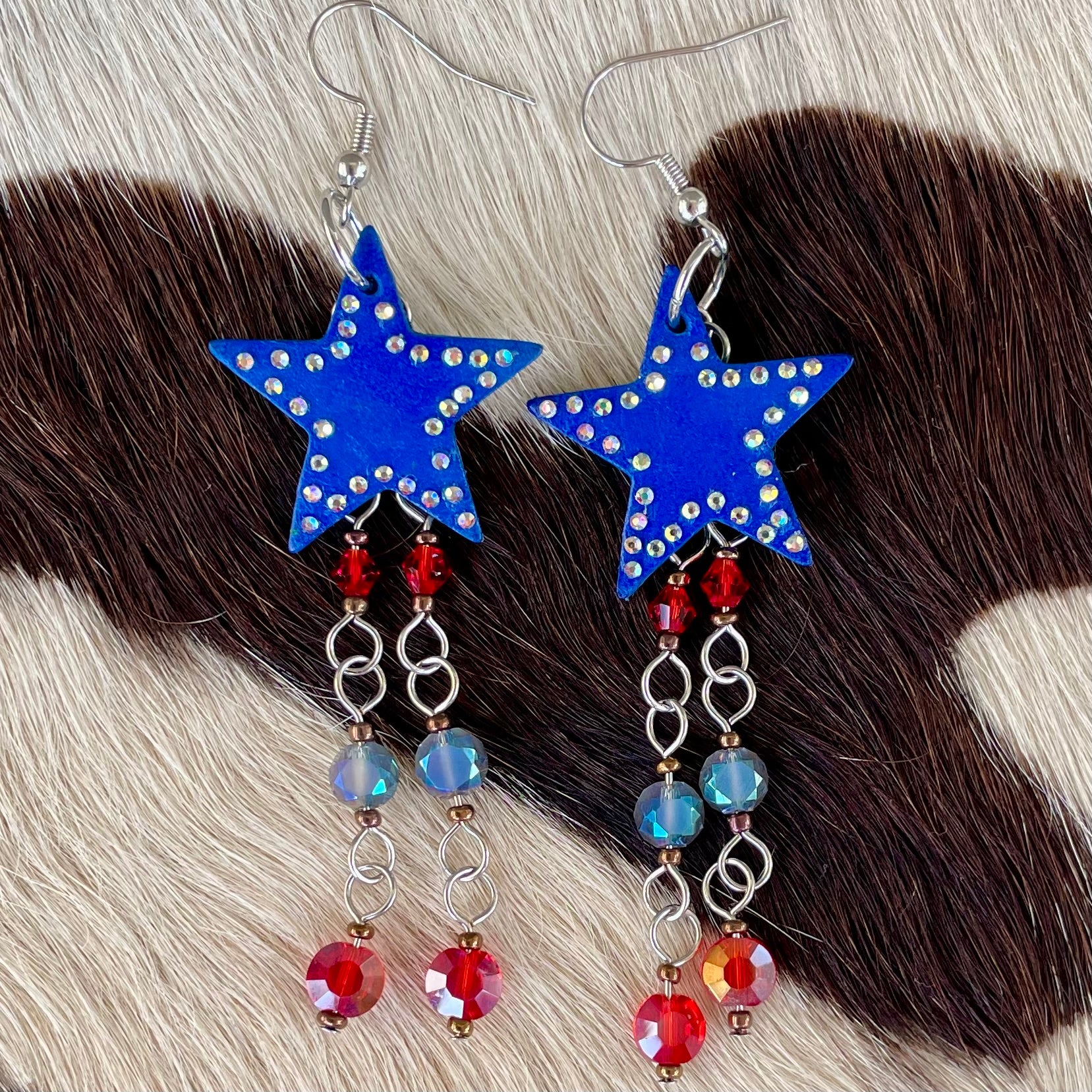Handmade dyed royal blue leather star earrings with red and blue hanging beads and AB crystal rhinestones western inspired patriotic jewelry for cowgirls and rodeo fashion lovers