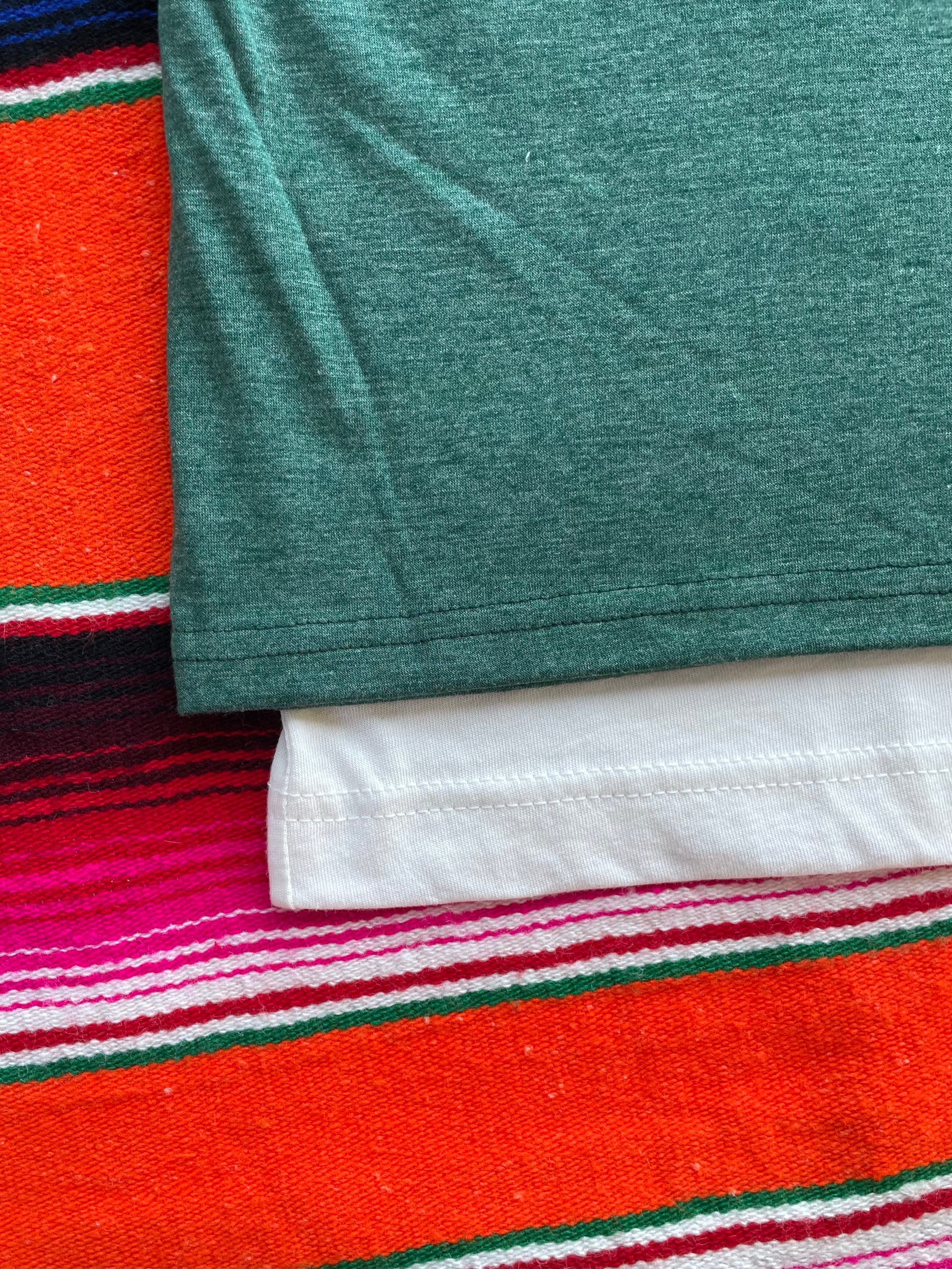 Close-up of green fabric on a colorful striped background