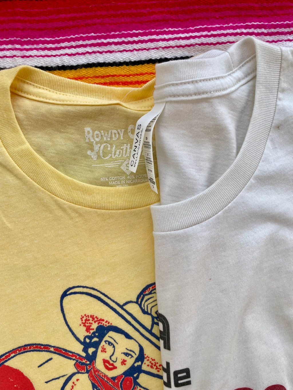 Yellow t-shirt with a graphic design of a woman in a hat and skirt, cactus, and sun on a colorful striped background.