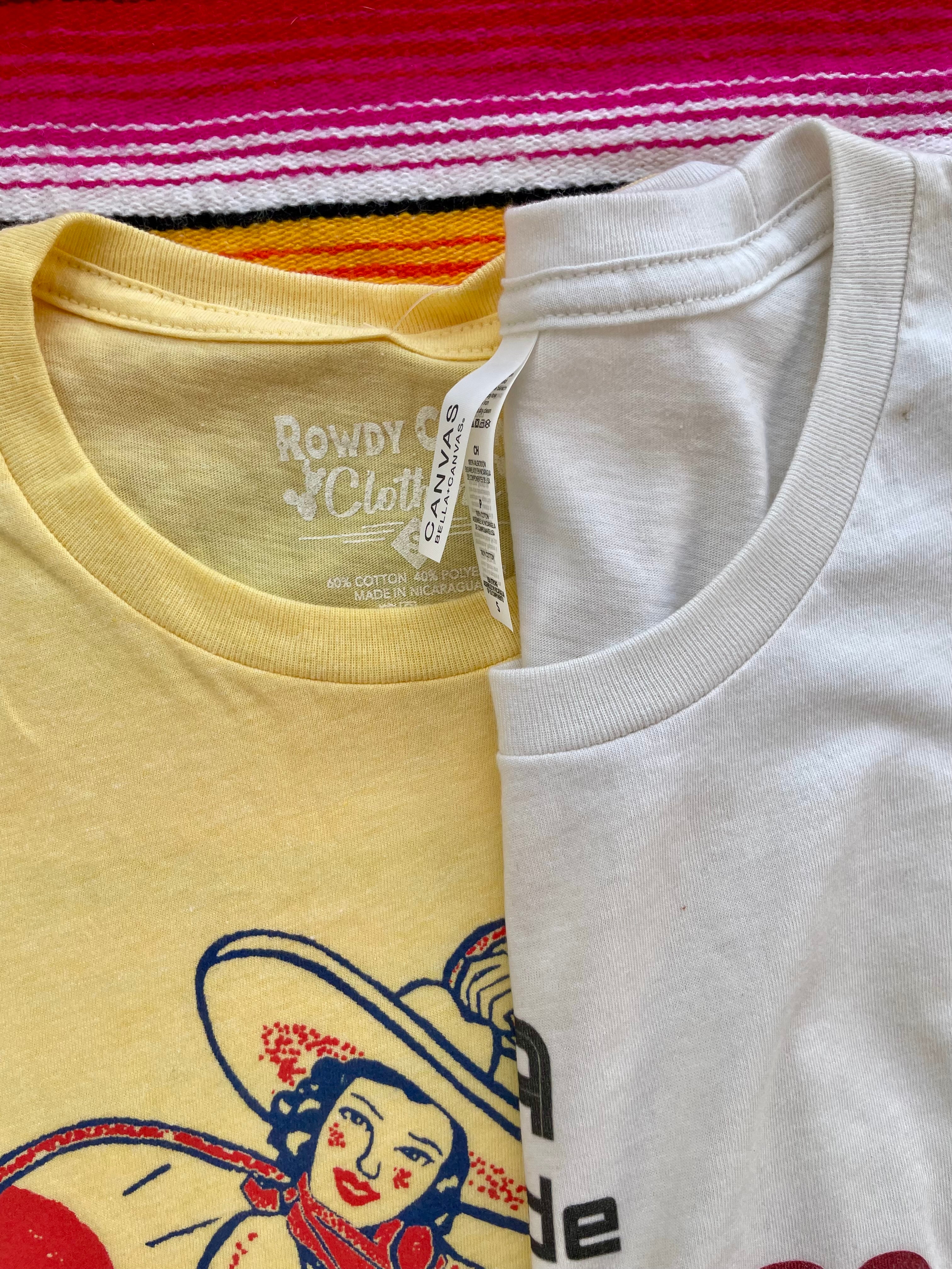 Yellow t-shirt with a graphic design of a woman in a hat and skirt, cactus, and sun on a colorful striped background.