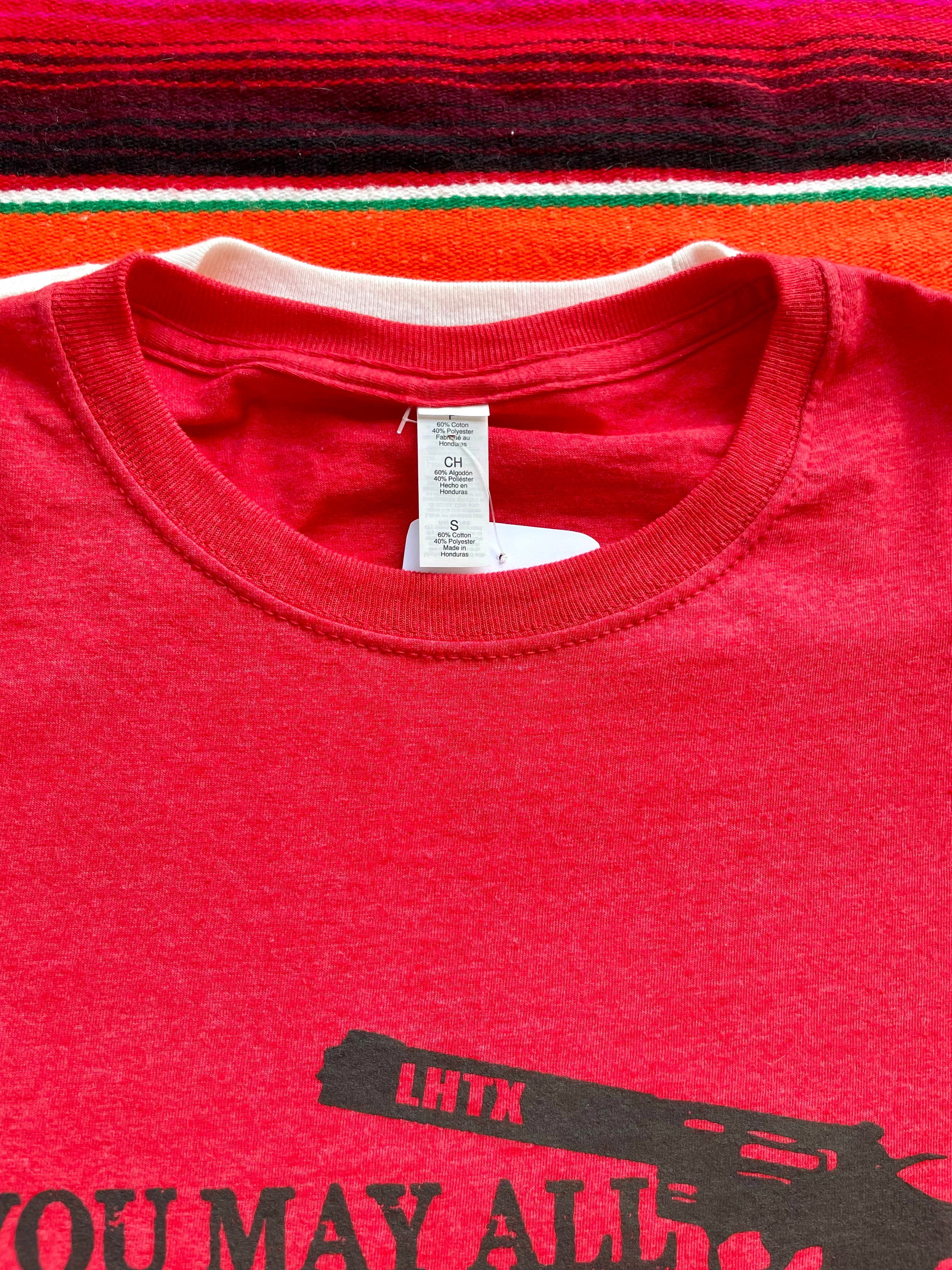 Red women’s graphic tee featuring Davy Crockett’s iconic quote “You may all go to hell and I will go to Texas.” Western slogan shirt rooted in Texas, designed by LHTX for bold southern style and patriotic pride. Hand drawn gun and screen printed. 