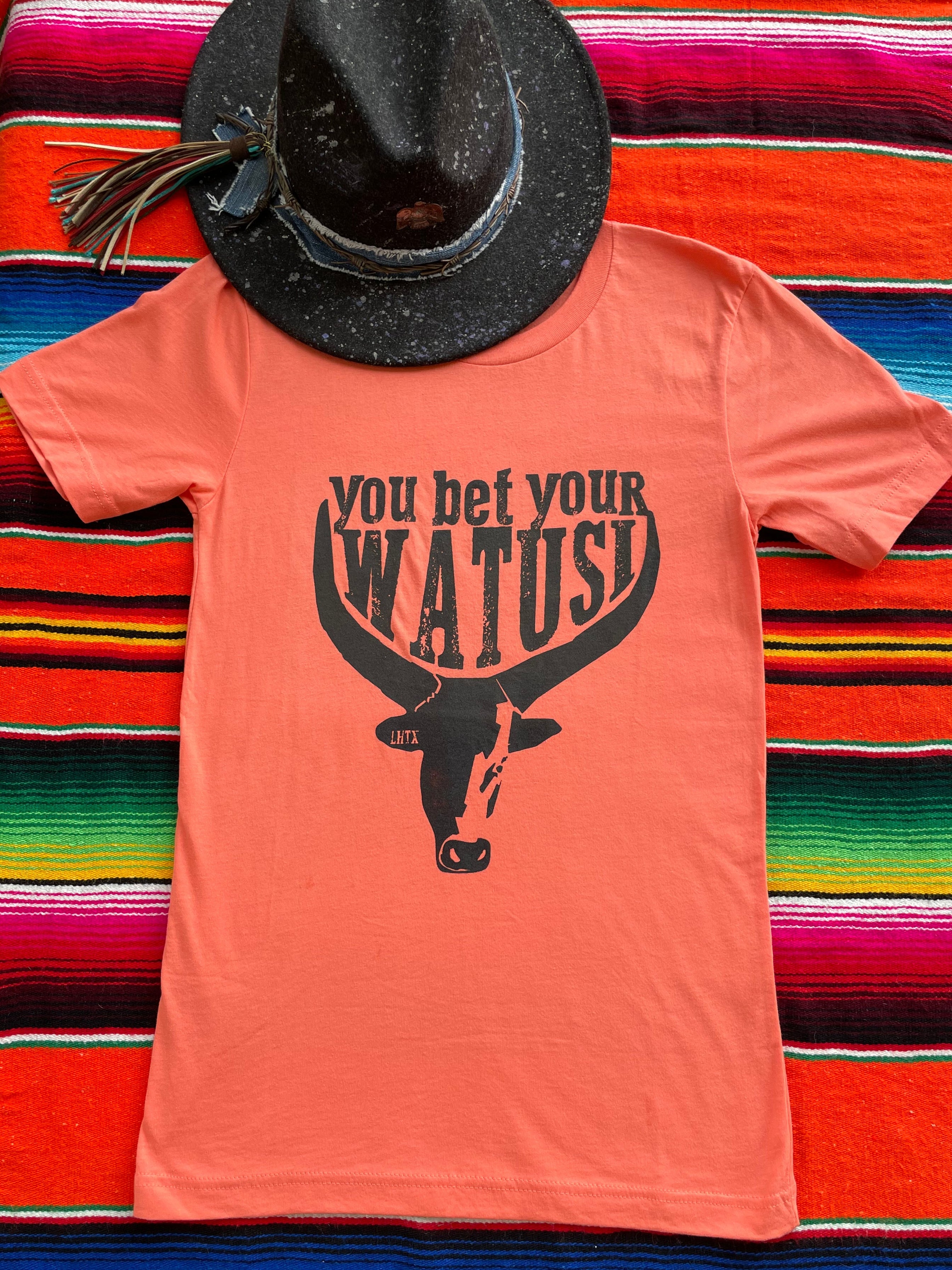 Tangerine cowgirl graphic t-shirt with "You Bet Your Watusi" slogan and illustrated by LHTX with a hand drawn Watusi bullhead western fashion apparel by the Bucktooth Horse