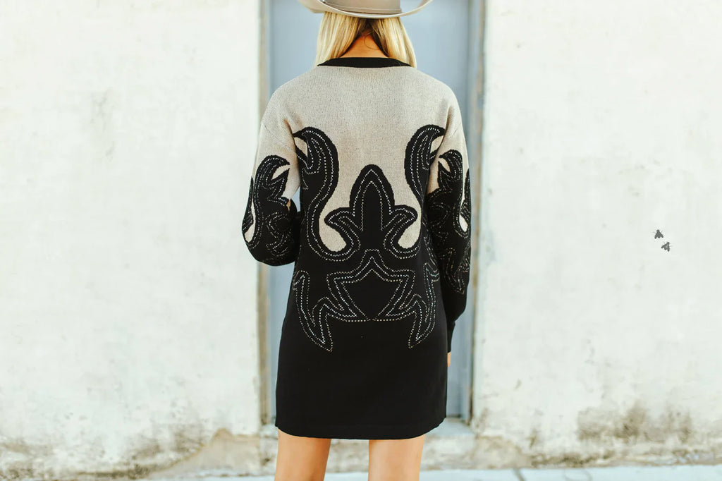 Woman wearing a black and beige patterned western style boot print dress with a cowboy hat