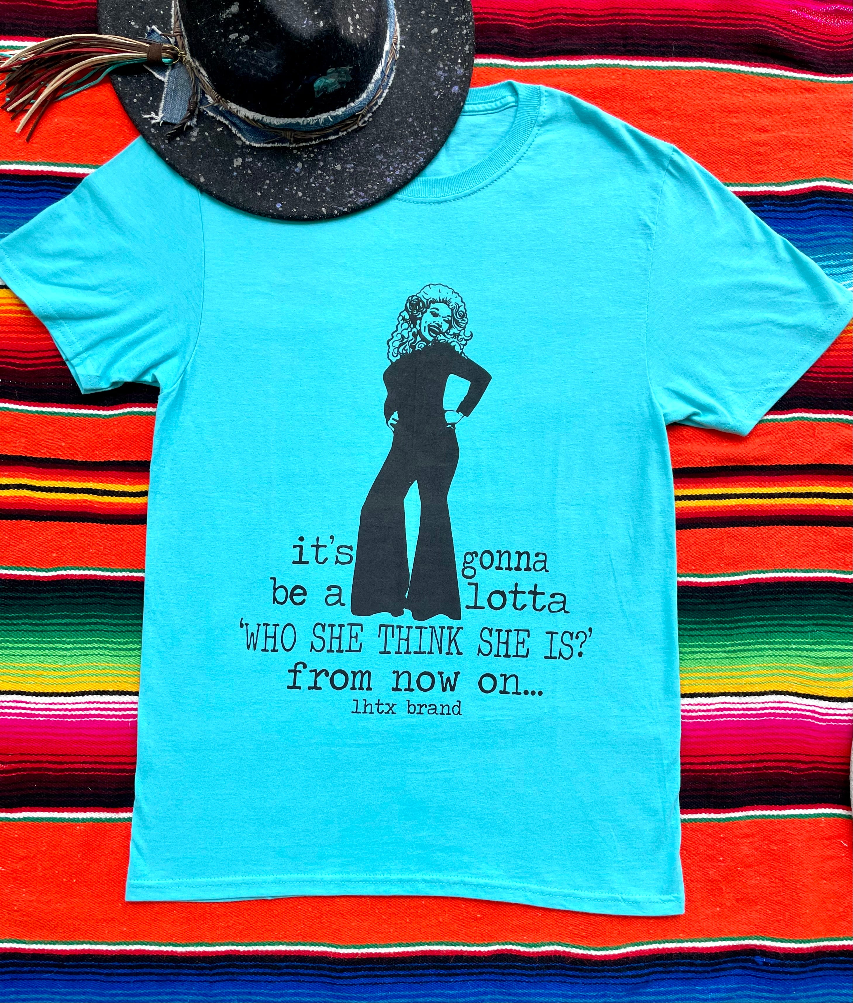 Light blue t-shirt with a graphic and text on a colorful striped background
