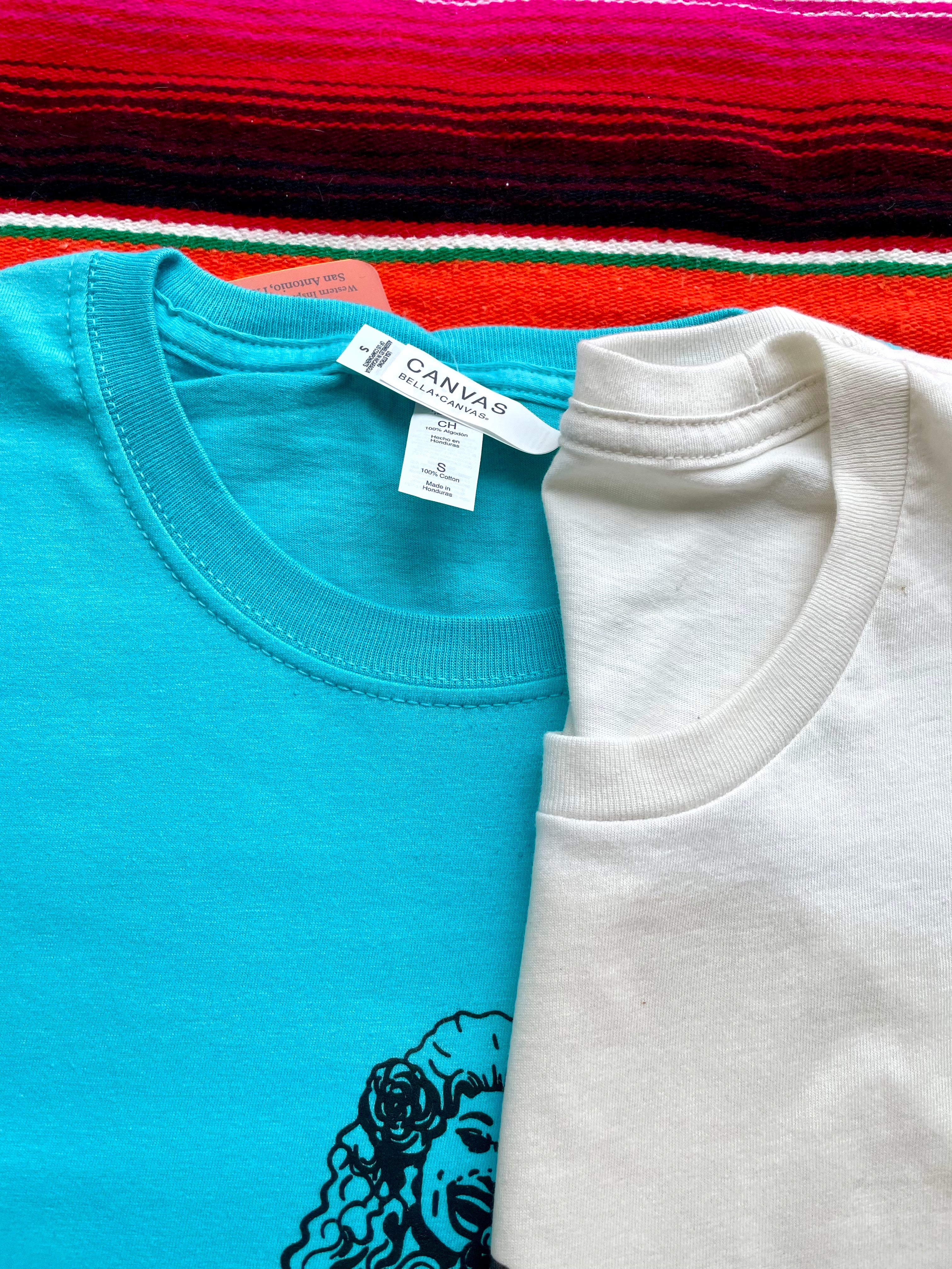 Two shirts, one blue and one white, with a visible Canva tag on a colorful striped background.