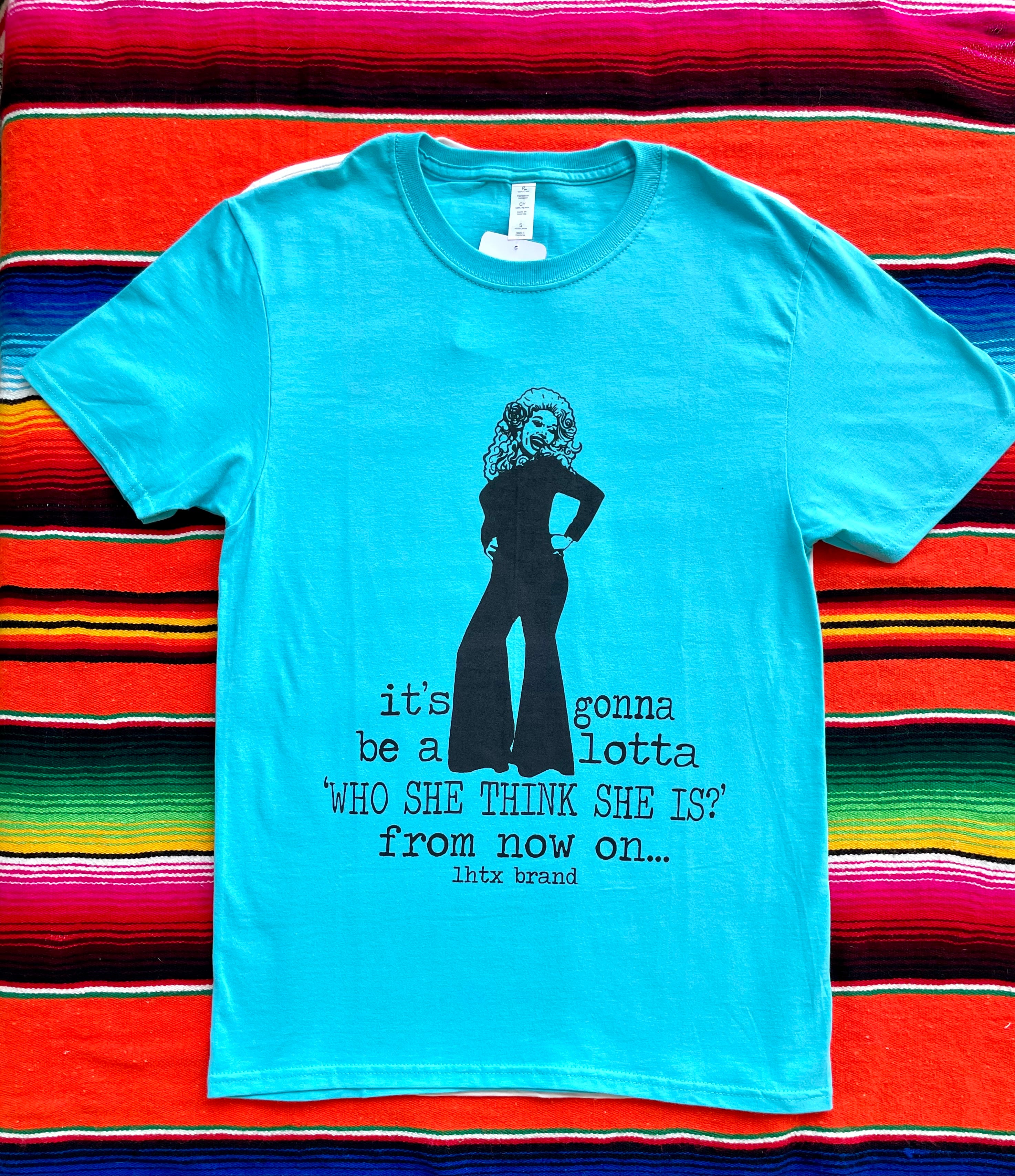 Light blue t-shirt with black graphic and text on a colorful striped background