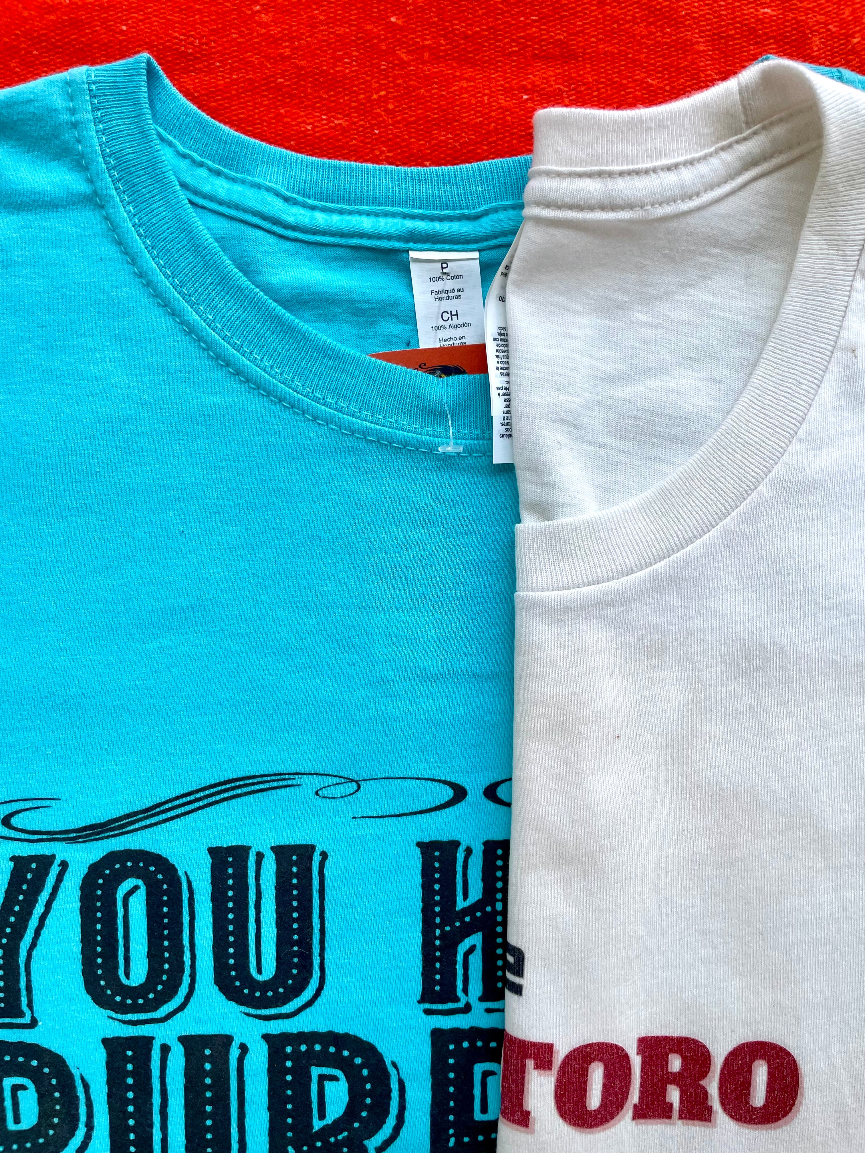 Inspirational unisex graphic t-shirt in turquoise with bold motivational quote on colorful background